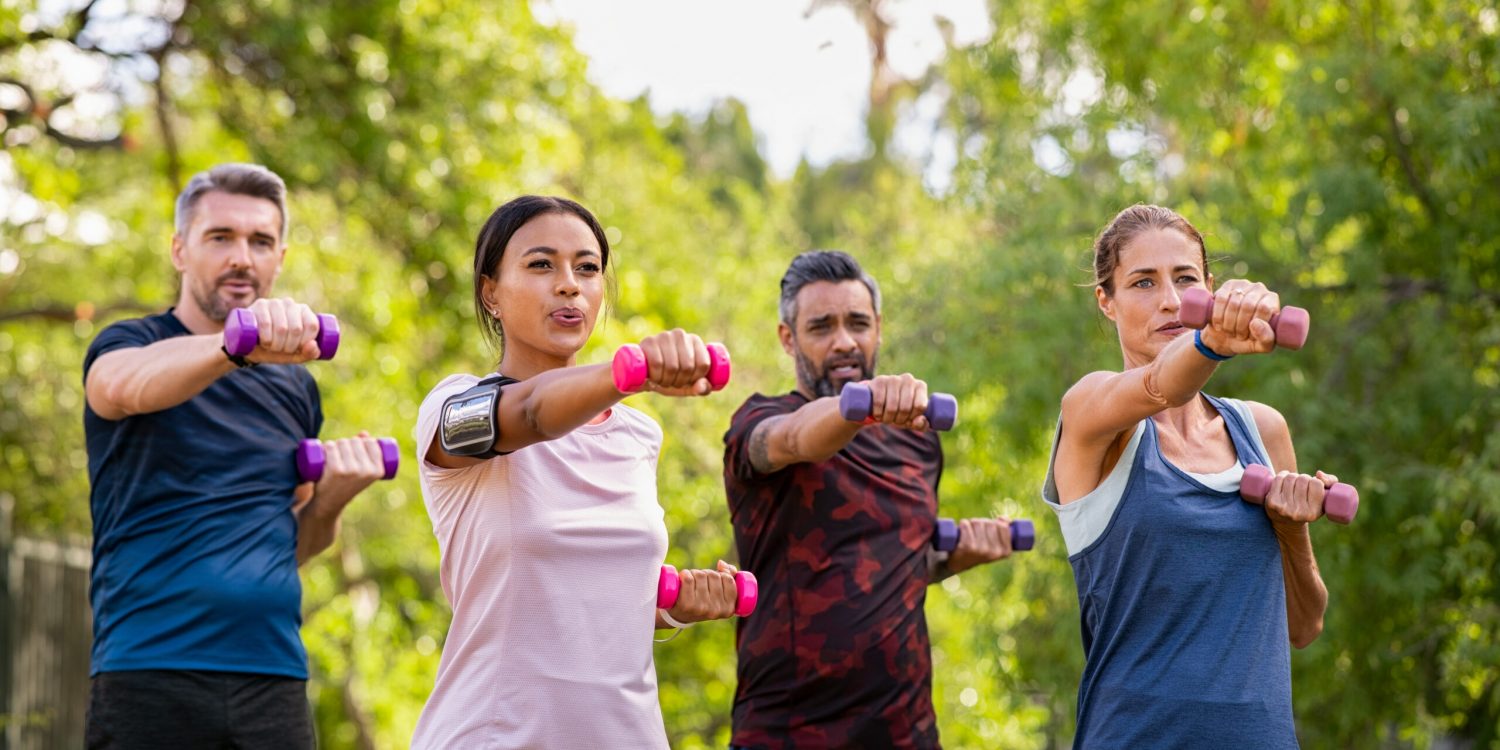 Group,Of,Mature,Friends,Exercise,Using,Dumbbells,At,Park.,Team
